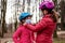 The older sister puts on the younger one a medical mask before riding a Bicycle. The concept of protection FROM covid-19