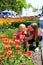 The older sister teaches the younger to smell tulips on a city flowerbed