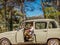 Older smiling man  sitting in his car in sunny day