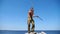 Older sportsman demonstrating wing chun kung fu against blue sea at background. Adult male athlete showing fighting