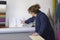 Older woman in a furniture factory is checking notebook for measures