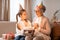 Older Woman and Girl Sitting on Couch With Birthday Cake