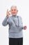 Older woman making the victory sign on a white background