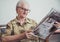 Older woman relaxing and reading newspaper