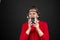 Older woman with a set of retro corded headphones in a red sweater dancing and enjoying music