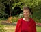 Older Woman Smiling In Garden Setting