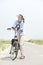 Older woman standing relaxing with bicycle on path