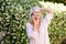 Older woman talking on phone with hand to head outside