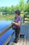 Older woman views pond with portable oxygen tube