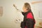 Older worker fixing dowel holes in apartment walls before painting