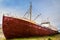 Oldest steel ship in Iceland abandoned rusty ashore in the grass