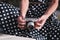 Oldschool mirrorless camera in the hands of a girl in a white and black dot dress