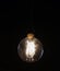 Oldstyle wolfram light bulb shining in the dark