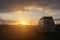 Oldtimer campervan parking at the ocean while the sun sets