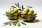 Olive filled bowls with elegant olive twig accents on a white surface