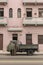 Olive green truck and pink building Havana