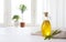 Olive oil bottle on table against sunlit kitchen window background