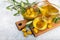 Olive oil in glass bowls, gravy boats and bottle on a textured kitchen table.