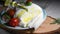 olive oil is pouring onto fresh mozzarella of Puglia, gently flowing into pieces of cheese, food made in Italy, regional cuisine,