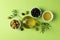 Olives, bottle and bowl with olive oil on background, top view