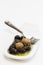 Olives, oil and spice on white plate