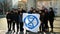 OLOMOUC, CZECH REPUBLIC, JANUARY 10, 2019: Extinction rebellion activist banner symbol circle hourglass is warning, men