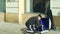 OLOMOUC, CZECH REPUBLIC, JANUARY 29, 2019: Gypsy man in city begging money into a cup, fake beggar recalculates and