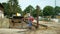 OLOMOUC, CZECH REPUBLIC, JUNE 11, 2019: Cows cowshed cleaning from manure and faeces, budozer JCB and farm worker with