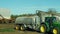 OLOMOUC, CZECH REPUBLIC, SEPTEMBER 10, 2019: Tractor John Deere special trailer spreading fertilizer of slurry on field