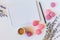 ?olorful french macarons, cup of coffee, clean notebook and flowers on white background. Top view, flat style.