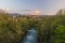 Oloron river and Oloron-Sainte-Marie city in sunset light. Mountains of French Atlantic Pyrenees are at background