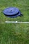 Olympic barbell with black weight plates on a green lawn, ready for an outdoor workout