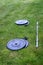 Olympic barbell with black weight plates on a green lawn, ready for an outdoor workout