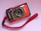 Olympus TG-5 tough waterproofed compact digital camera on a pink background