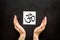 Om - Buddhist inner peace symbol - in hands on black desk top view