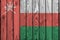 Oman flag depicted in bright paint colors on old wooden wall. Textured banner on rough background