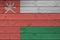 Oman flag depicted in bright paint colors on old wooden wall. Textured banner on rough background