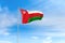 Oman flag over blue sky background
