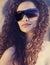 Oman with gorgeous curly hair wearing sunglasses