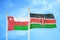 Oman and Kenya two flags on flagpoles and blue sky