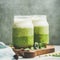 Ombre layered green smoothies with mint in jars, square crop