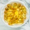 Omega 3 fish oil capsules in a white dish on a light background. Medical food supplies. Unsaturated fatty acid