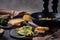 Omelet with broccoli and green onions on a black plate and frying pan on a black background close up