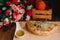 Omelet pieces on a wooden cooking desk with oil, tomatoes and a bouquet of flowers on the sides