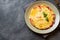 Omelet, scrambled eggs with tomatoes and cheese in a plate on a dark table