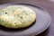 Omelet with spinach and zucchini with melted cheese on brown plate