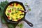 Omelet with vegetables in a cast-iron pan