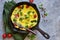 Omelet with vegetables in a cast-iron pan