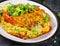 Omelette with tomatoes, avocado, blue cheese and green peasOmelette with tomatoes, avocado, blue cheese and green peas on white pl