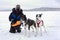 Omen petting husky dogs after tourist sled ride